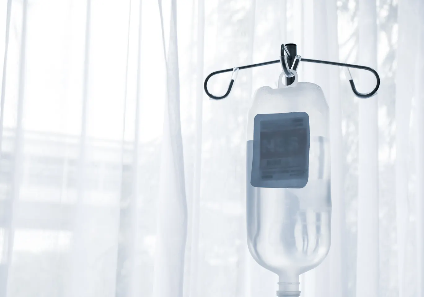 Kroplówki witaminowe Złotoryja: butelka płynu infuzyjnego zawieszona przy oknie