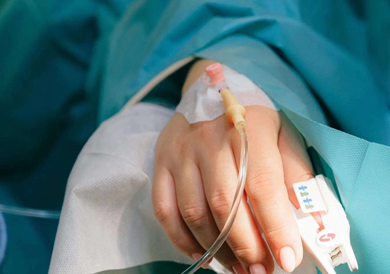 Detoks alkoholowy Bolesławiec: dłoń z wenflonem i pulsoksymetrem pod nadzorem