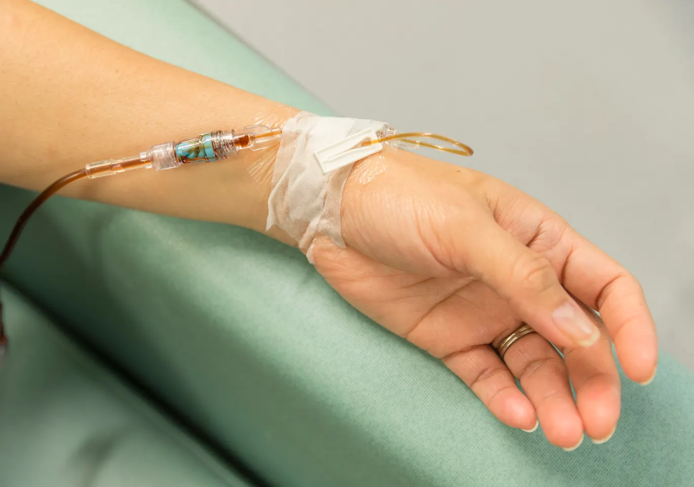 Kroplówki witaminowe Złotoryja: dłoń z wenflonem i linią infuzyjną na podkładzie